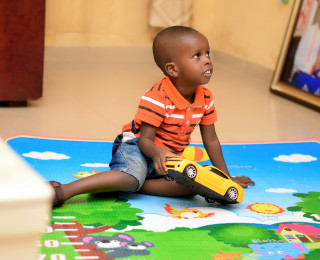 toddler in nursery playing with car toy