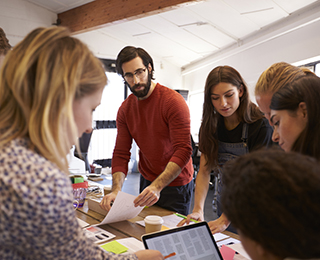 young adults circled around table meeting